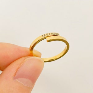 May include: A gold-toned ring with the date "14/11/1979" engraved on it.