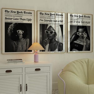 May include: Three framed black and white prints with the text "The New York Trends" and various headlines. A white cabinet with a lamp and a beanbag chair are in the foreground.