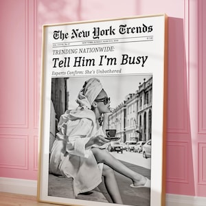 Puede incluir: Un estampado enmarcado con una imagen en blanco y negro de una mujer con una bata y gafas de sol, sosteniendo una taza de café. El estampado es un periódico simulado titulado "The New York Trends" con el titular "Tell Him I'm Busy."