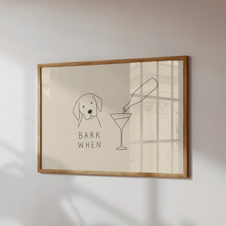 K&ouml;nnte beinhalten: Ein gerahmter Kunstdruck mit einer minimalistischen schwarzen Strichzeichnung auf beigem Hintergrund. Die Abbildung zeigt einen Hund neben einem Martiniglas, das aus einer Flasche gef&uuml;llt wird, mit dem Text BARK WHEN unter dem Kopf.