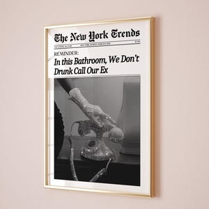 May include: A black and white photograph of a hand reaching for a rotary phone. The photo is printed on a newspaper with the headline "The New York Trends" and the text "REMINDER: In this Bathroom, We Don't Drunk Call Our Ex".