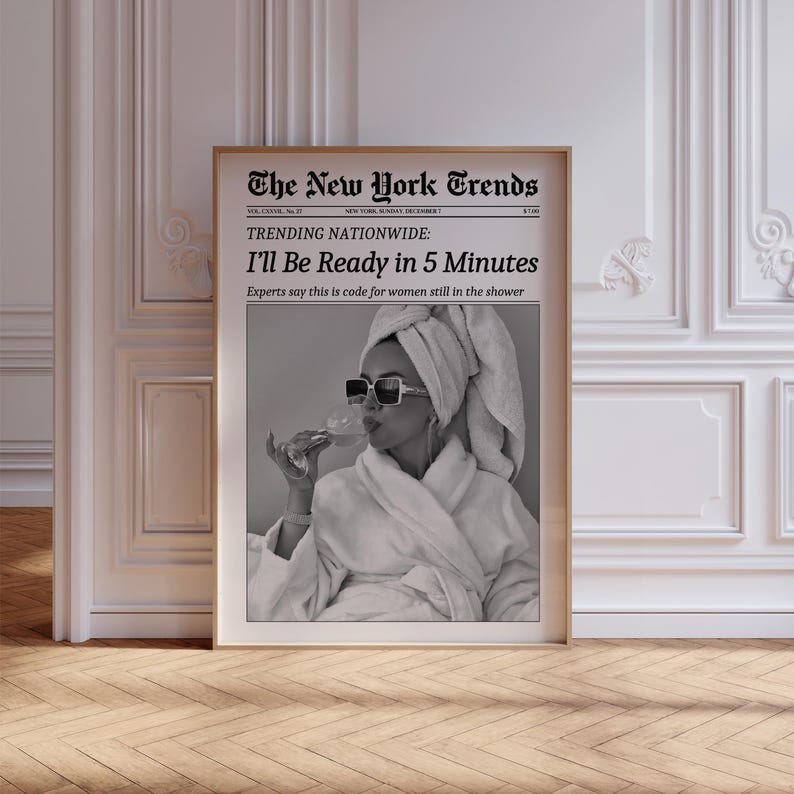 K&ouml;nnte beinhalten: Ein gerahmter Schwarz-Wei&szlig;-Druck mit der &Uuml;berschrift "The New York Trends". Der Druck zeigt den Text "I'll Be Ready in 5 Minutes" und ein Bild einer Person mit Sonnenbrille und einem Handtuch auf dem Kopf. Der Druck ist in einem goldenen Rahmen.