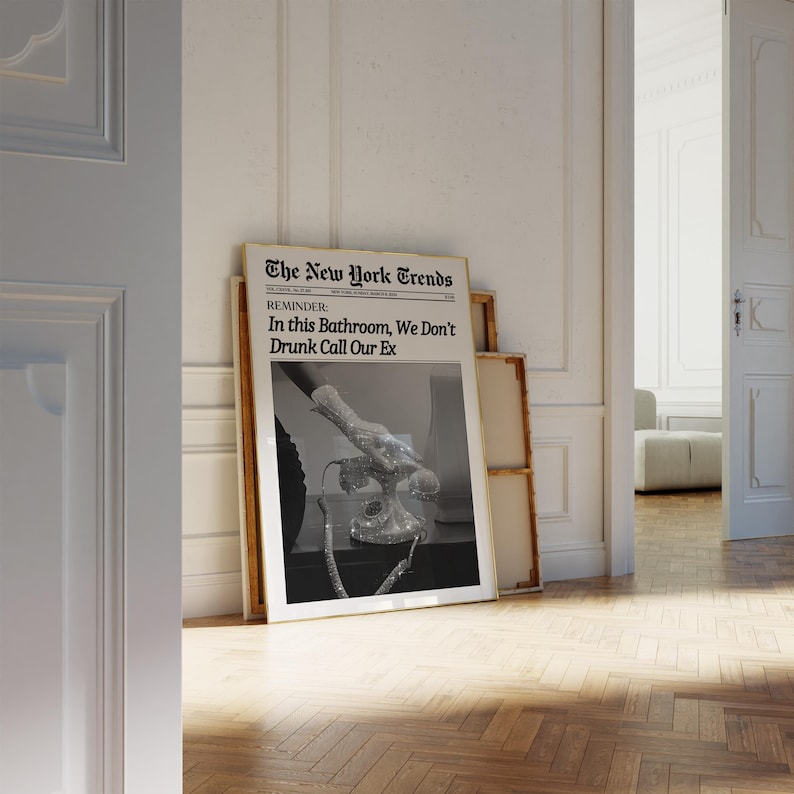 May include: A black and white photograph of a hand wearing a sparkly glove holding a rhinestone-covered rotary phone. The photo is framed and has the text "The New York Trends" and "REMINDER: In this Bathroom, We Don't Drunk Call Our Ex" printed on it.