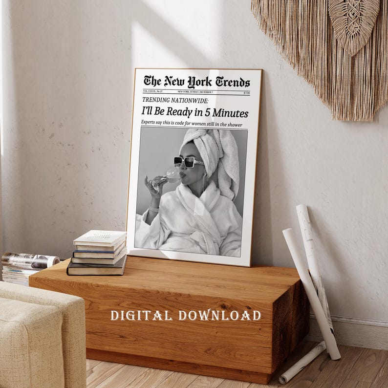 K&ouml;nnte beinhalten: Ein gerahmter Schwarz-Wei&szlig;-Druck mit dem Text "The New York Trends" und "I'll Be Ready in 5 Minutes". Das Bild zeigt eine Person im Bademantel und Sonnenbrille. Die Worte "DIGITAL DOWNLOAD" stehen unten.