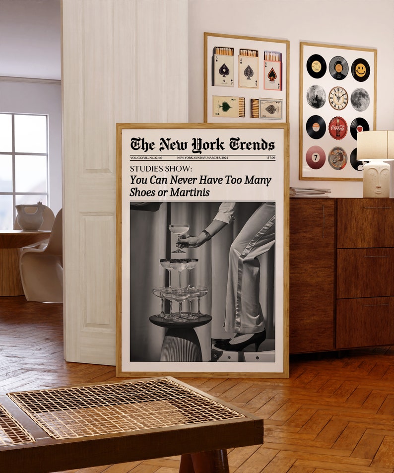 May include: A black and white photo of a woman wearing a white pantsuit and heels, reaching for a martini glass. The photo is framed and has the text "The New York Trends" and "STUDIES SHOW: You Can Never Have Too Many Shoes or Martinis" printed on it.