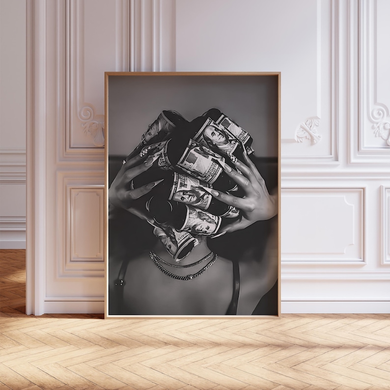 May include: Black and white framed print featuring a person with long nails holding rolled-up US dollar bills. The person is wearing a necklace and a dark top. The image is a close-up shot.
