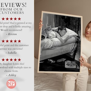 May include: Black and white photo print of a woman sleeping in bed with a cat. The print is framed and being held by a person. The photo is accompanied by customer reviews praising the quality of the print and the customer service.