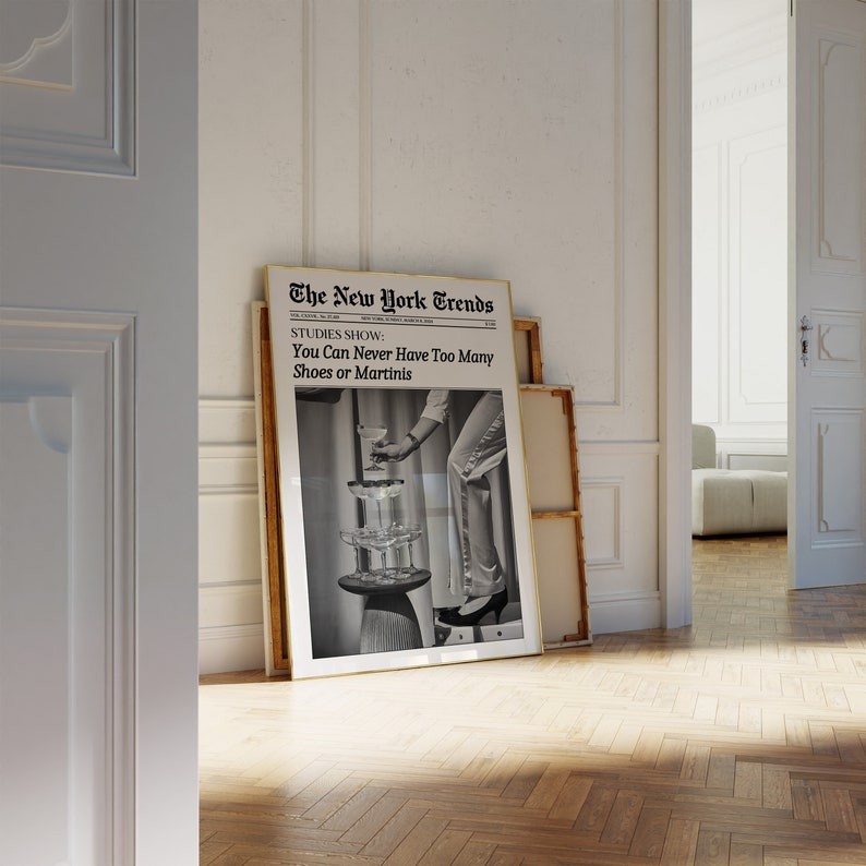 May include: A black and white photo of a woman wearing a pair of high heels and holding a martini glass. The photo is framed and has a gold border. The photo is titled "The New York Trends" and has the text "STUDIES SHOW: You Can Never Have Too Many Shoes or Martinis".