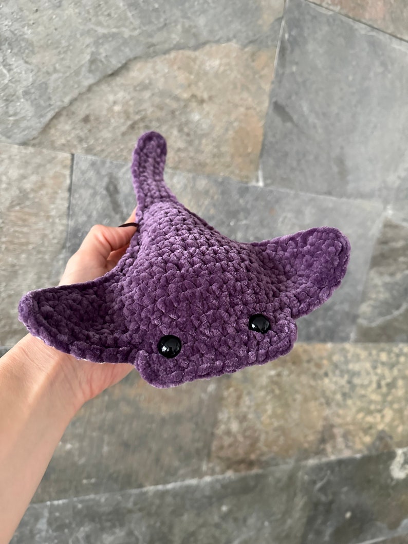 May include: A purple crocheted stingray plush toy with black eyes.