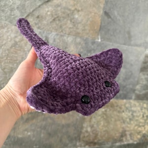 May include: A crocheted purple stingray plush toy with black eyes.