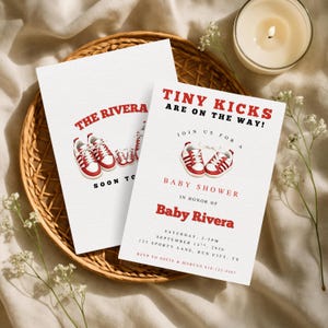 May include: Two white rectangular baby shower invitation cards featuring red and white sneaker illustrations. The text reads: Tiny Kicks Are On The Way! Join Us For A Baby Shower In Honor Of Baby Rivera, Saturday, September 14th, 2026, 123 Sporty Lane, Run City, TX, RSVP to Sofia & Marcus 818-123-4567.