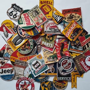 Può includere: Una collezione di adesivi in stile vintage con temi automobilistici e di stazioni di servizio. I disegni includono i loghi Route 66, Shell Oil, Castrol, Jeep e Texaco, con vari colori e grafiche.