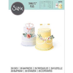 May include: A Sizzix Thinlits Plus die set featuring two decorative cake designs. One cake is white with a pink bow and rose, the other is yellow with daisy accents. The set includes 29 dies for crafting.