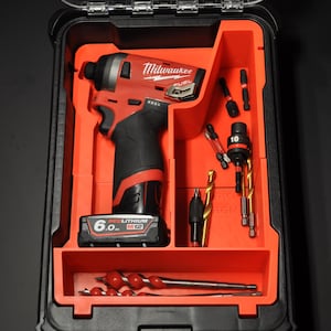 May include: A black and red tool case with a red foam insert. The case contains a Milwaukee FUEL 12V drill, a 6.0 Ah battery, and various drill bits and screw driver bits.