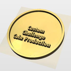 May include: A gold-colored coin with the text "Custom Challenge Coin Production" in a 3D style. The coin has a black border and sits on a white surface. The text is in a bold, sans-serif font.