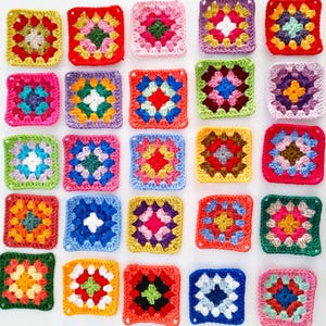 Puede incluir: Una colección de veinticinco cuadrados de ganchillo dispuestos en una cuadrícula de cinco por cinco. Cada cuadrado presenta una combinación única de colores de hilo vibrantes que incluyen rojo, amarillo, azul, verde, rosa, morado y blanco.