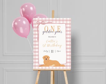 Tabliczka powitalna z okazji pierwszych urodzin „One Golden Year”, różowy pies i kokardy, szablon do pobrania w wersji cyfrowej