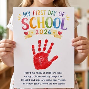 May include: A white rectangular sign featuring the colorful text MY FIRST DAY OF SCHOOL 2026 with a yellow banner and red hearts. A large red handprint is centered on the page above a poem that reads Here's my hand, so small and new.