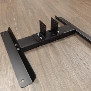 Könnte beinhalten: Schwarzer Metallständer mit zwei vertikalen Stützen und einer horizontalen Stange. Der Ständer trägt ein Logo mit der Aufschrift "Maxerich".