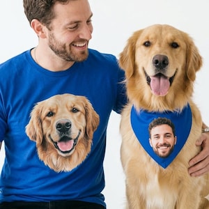 Op de afbeelding: Een man en een Golden Retriever-hond worden getoond. De man draagt een blauw t-shirt met een groot beeld van het gezicht van een Golden Retriever. De hond draagt een blauwe bandana met een foto van het gezicht van een man. Beiden lachen.