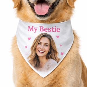May include: A smiling Golden Retriever wearing a white bandana printed with "My Bestie" in pink, a photo of a woman, and pink hearts. The dog's tongue is visible. The background is white.