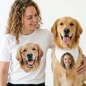 Pode incluir: Uma t-shirt branca com um retrato realista de um cão golden retriever. Ao lado, um golden retriever usa uma bandana branca estampada com o retrato realista de uma pessoa de cabelo encaracolado, combinando com o estilo da estampa da t-shirt.