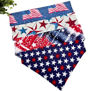 May include: A stack of patriotic bandanas with various designs. The top bandana features the American flag on a blue background. Other bandanas display red and white stars, and a red, white, and blue starburst pattern. The bottom bandana has a blue background with white and red stars.