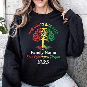 May include: Black sweatshirt with a tree graphic in red, yellow, and green, with the text "OUR ROOTS RUN DEEP." Below the tree is "Family Name" and "Our Love Runs Deeper 2025."