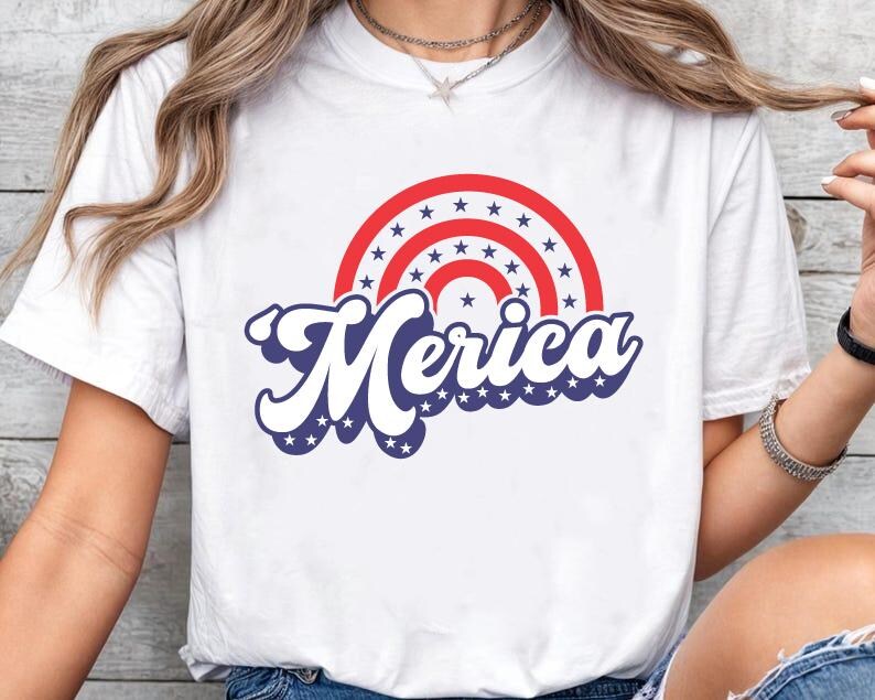 May include: White t-shirt featuring a red, white and blue graphic of a rainbow with stars and the word "Merica" in a retro font.