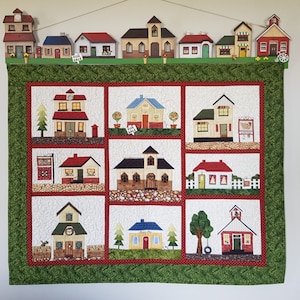 Downloadable pattern for a stunning paper pieced quilted wall hanging, Little Village Down South, depicting a quaint rural village.