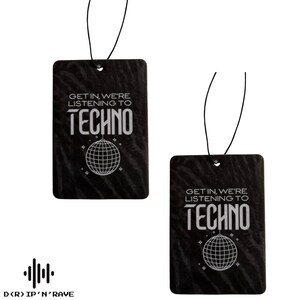 May include: Two black rectangular air fresheners with the text "GET IN, WE'RE LISTENING TO TECHNO" and a disco ball graphic. Each freshener has a black string for hanging. The bottom of the image has the text "D(R) IP'N'RAVE".