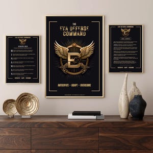 Puede incluir: Tres carteles enmarcados en negro con detalles dorados. El cartel del centro tiene una 'E' dorada con alas y un círculo dorado a su alrededor. El texto del cartel del centro dice "The Eva Defense Command" y "Anticipate - Adapt - Overcome". El cartel de la izquierda tiene el texto "Eva Defense Command" y "Wingman Creed". El cartel de la derecha tiene el texto "Eva Defense Command" y "Code of Conduct".