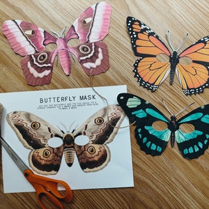 May include: A craft project with instructions for making a butterfly mask. The image shows three butterfly cutouts, a spool of twine, scissors, and a printed sheet with instructions to cut out the butterfly and eye holes, tie a string through the holes and around your head to make a mask.