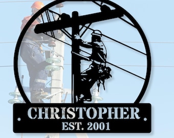 May include: Black metal wall art depicting a lineman working on a power pole, framed by a circle. The art includes the name "CHRISTOPHER" and the year "EST. 2001" on a rectangular plaque. A blurred image of a lineman is in the background.