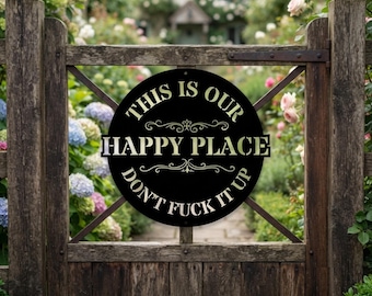 May include: A circular black metal sign featuring the text THIS IS OUR HAPPY PLACE DON'T FUCK IT UP in a light-colored font. The sign includes decorative scrollwork accents above and below the words HAPPY PLACE and is mounted on a wooden gate.