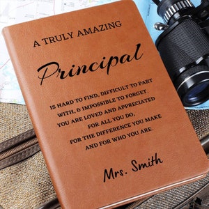 May include: A brown leather journal with the text "A Truly Amazing Principal" and a message about how hard it is to find a good principal. The journal is personalized with the name "Mrs. Smith".