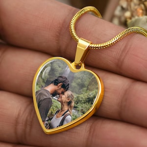 Hand-held gold heart pendant on a snake chain, glossy bezel showing a full-color couple picture, custom photo heart necklace