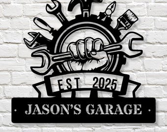 May include: Black metal garage sign with a wrench, hammer, paintbrush, and other tools surrounding a fist holding a wrench. The sign reads "EST 2025" and "JASON'S GARAGE".