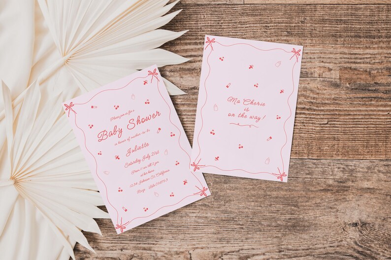 May include: Two pink baby shower invitations with red and white text. The larger invitation says "Baby Shower" and includes details about the event. The smaller invitation says "Ma Cherie is on the way!"