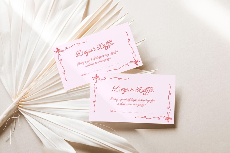 May include: Two pink cards with red text and a red ribbon design. The text on the cards reads "Diaper Raffle" and "Bring a pack of diapers any size for a chance to win a prize!"