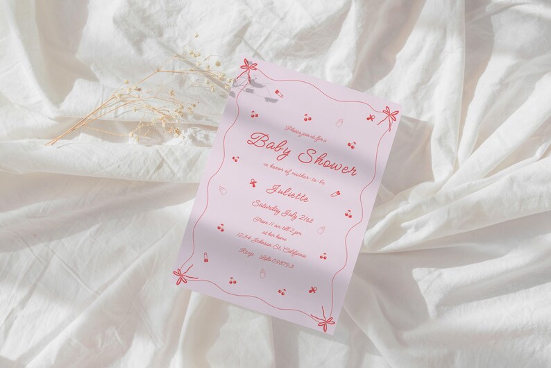 May include: Pink baby shower invitation with red floral accents and the text "Baby Shower" in cursive. The invitation is for Juliette and is set for Saturday, July 21st at 1 p.m. at the host's home. The address is 1234 Delicious Dr. California. RSVP by July 15th.