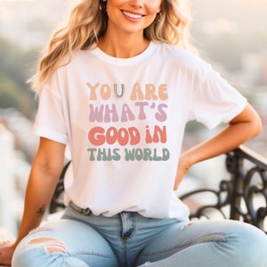 May include: White t-shirt with a colorful graphic that reads "You are what's good in this world".
