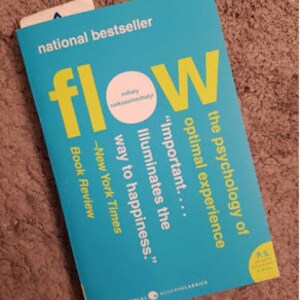Puede incluir: Un libro azul turquesa con el título "Flow" en letras amarillas. El subtítulo es "La psicología de la experiencia óptima" y el libro se describe como un "bestseller nacional".