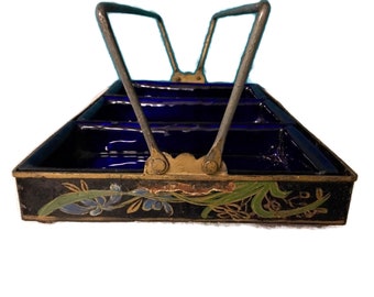 May include: A vintage black divided serving tray with a metal handle. The interior is a deep blue, and the exterior is decorated with floral designs in blue, green, and gold. The tray has a rectangular shape with a metal handle.