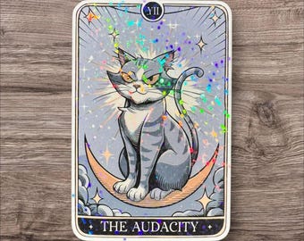 May include: A tarot card with a gray cat sitting on a crescent moon. The card is blue and white with a glittery finish. The card is labeled "VIII THE AUDACITY".