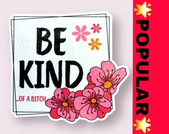 May include: White sticker with black text that reads "Be Kind...of a Bitch" with pink and orange flowers around the text.