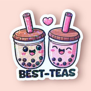 May include: Two cartoon bubble tea cups with smiling faces and pink straws. The cups are filled with brown and white boba pearls. The text "BEST-TEAS" is below the cups.