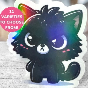 May include: A black holographic sticker of a cartoon cat with big eyes and a grumpy expression. The sticker has a rainbow iridescent finish. The text "11 VARIETIES TO CHOOSE FROM!" is on a pink starburst.