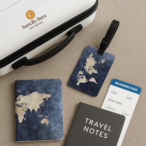May include: A travel set featuring a white suitcase, passport, luggage tag, notebook, and boarding pass. The items have a world map design on a blue background. The notebook reads "TRAVEL NOTES".