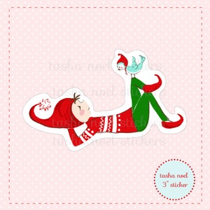 May include: A red and green elf with a white and red striped sweater is lying down with a blue bird perched on its leg. The elf is wearing a red hat with a white snowflake on it. The elf is 3 inches tall.